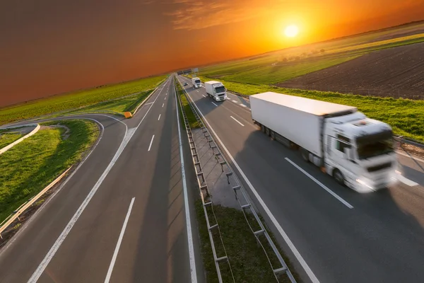 Delivery transport truck in motion blur on the highway at sunset