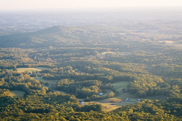 View of fields and houses in a valley from Pilot Mountain State