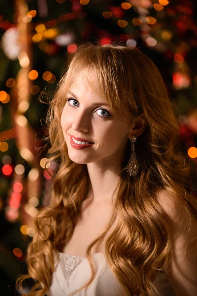 Young beautiful blond woman in the white dress on christmas, woman in a beautiful room with a Christmas tree and candles, a girl with gifts,  golden hair, happy woman new year, Redhead girl smiling