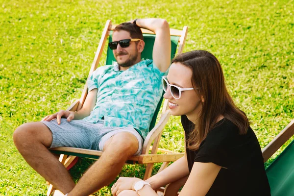 Happy People Relaxing and Communicate Outdoor on the Background with Green Grass.