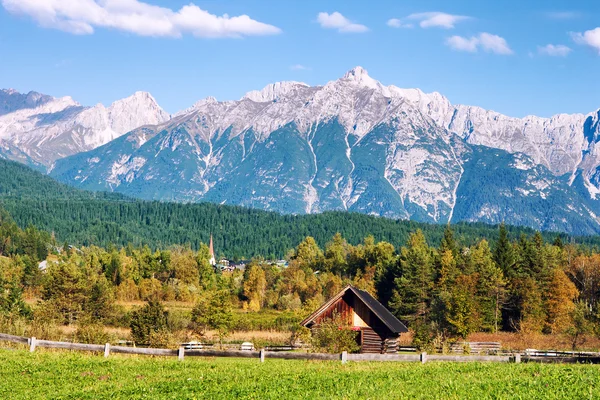 Idyllic tyrolean landscape with hills, forest, farm house and green fields