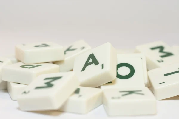 Heap of white plastic scrabble letters. Selective focus