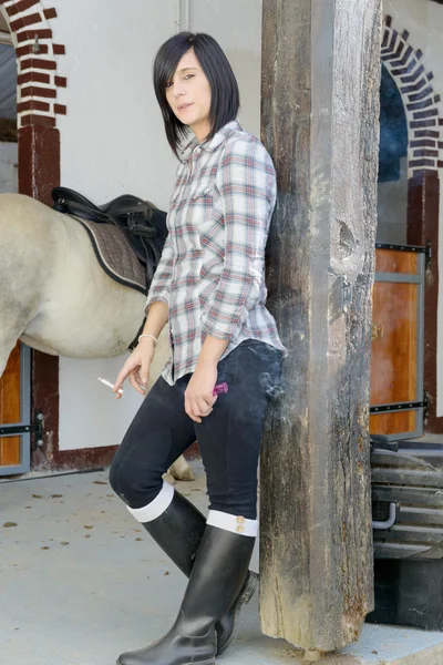 Brunette girl dressed in horse riding clothes