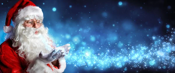 Santa Claus Blowing Magic Christmas Stars In Snowy Night