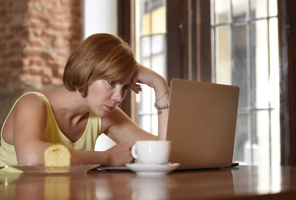 Beautiful successful woman working at coffee shop with laptop computer enjoying coffee cup