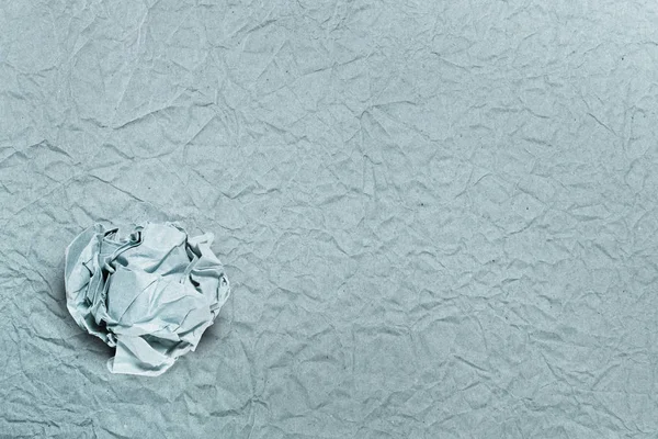 Crumpled paper ball on crumpled paper, for backgrounds or textur