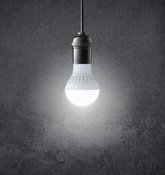 Glowing LED bulb on grunge wall