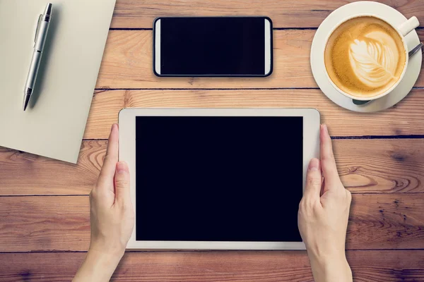 Hand woman holding tablet working on wood table in coffee shop w