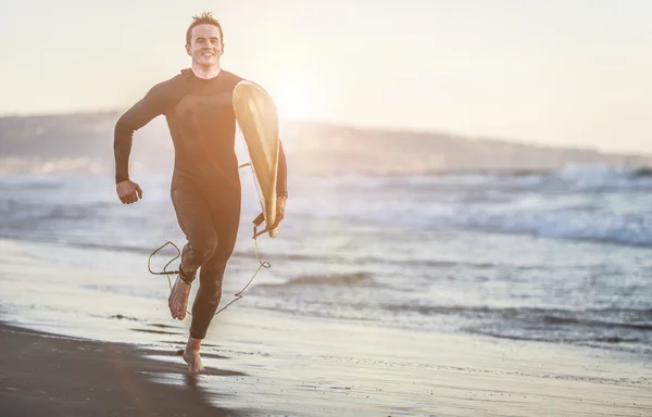 Surfer running on beach