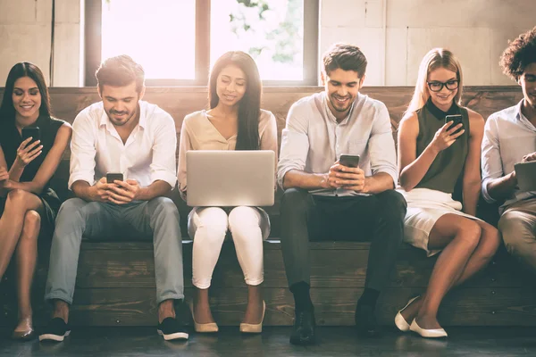 Young people holding different gadgets