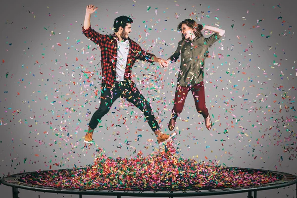 Cheerful couple jumping on trampoline