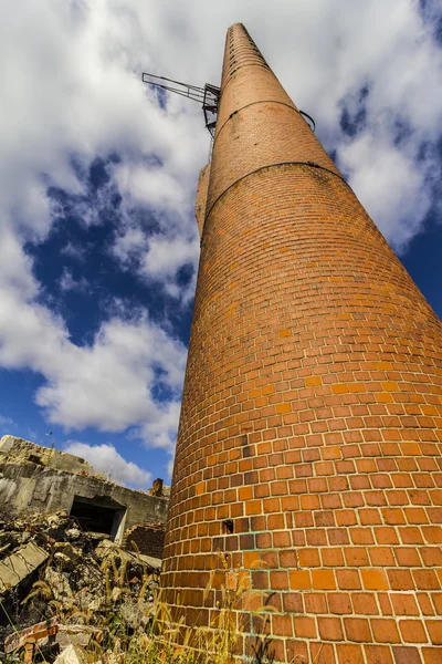 Abandoned Factory with Brick Smokestack and the Remnants of the