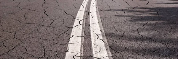 Dark asphalt road with cracks. Background panorama