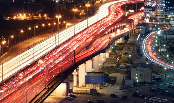 Traffic jam on automobile overpass at night, view from above. light trails of cars on a highway.