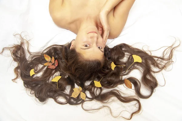 Yellow autumn leaves in the woman hairstyle