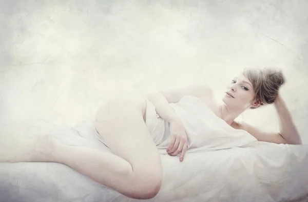 Young pretty woman naked in white sheets, textured vintage portrait, art seductive concept