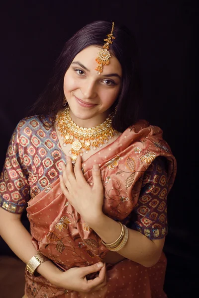 Beauty sweet real indian girl in sari smiling on black background