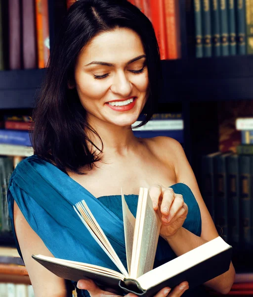Portrait of beauty young brunette woman reading book in library smiling, muslim girl in education, lifestyle people concept