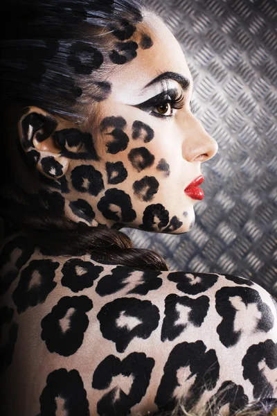 Young sexy woman with leopard make up all over body, cat bodyart, halloween look