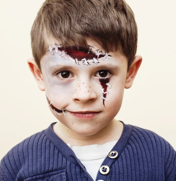 Little cute boy with facepaint like zombie apocalypse at hallowe