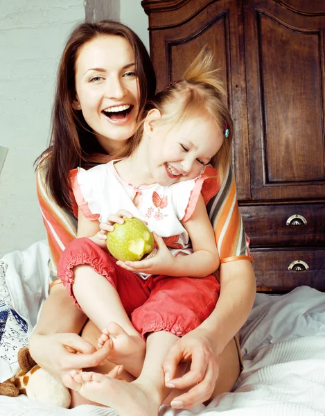 Mother with daughter together in bed smiling, happy family close up, lifestyle people concept, cool real modern family