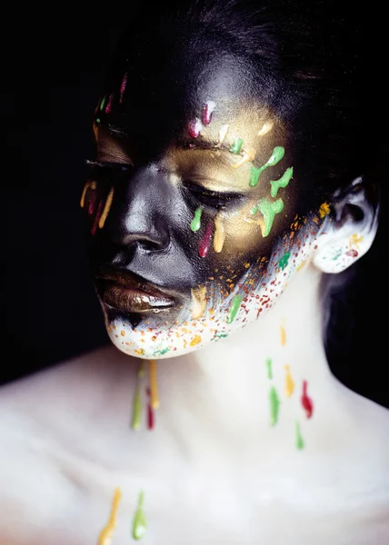 Woman with creative makeup closeup like drops of colors, facepai