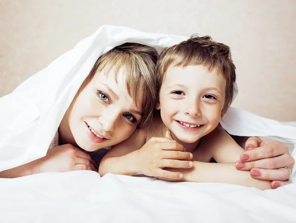 Mother with daughter together in bed smiling, happy family close up, lifestyle people concept, cool real modern family