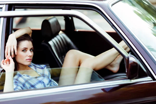 Girl with long legs sitting in car , tinted photo