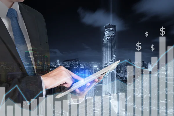 Double exposure of businessman using the tablet with city and fi