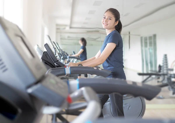 Asian woman walking,  running on treadmill gym workout.