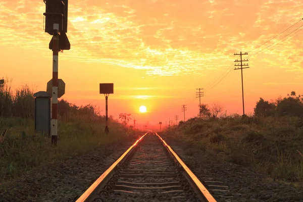 Railways track in trains against beautiful light of sun set sky