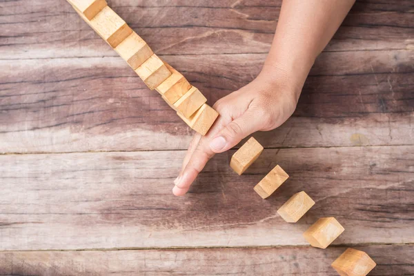 Hand stop wooden block. Domino risk effect concept