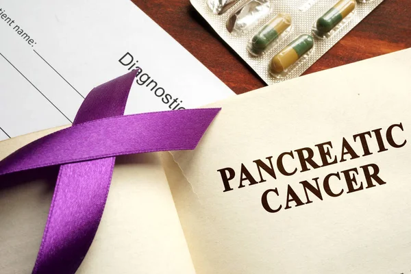Pancreatic cancer written on a page and  purple awareness ribbon.