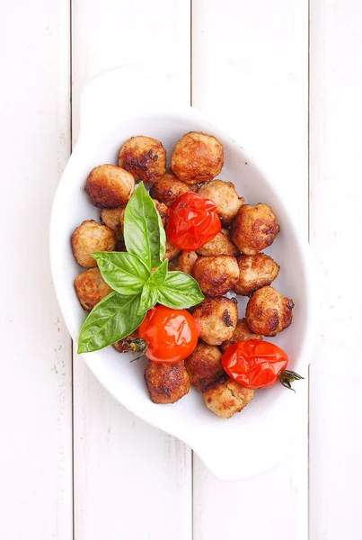 Meatballs with tomatoes on white plate