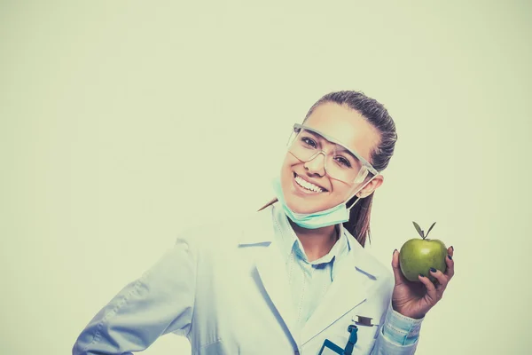 Smiling woman doctor with a green apple.