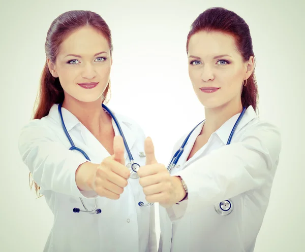 Two young woman doctor showing ok , standing in hospital