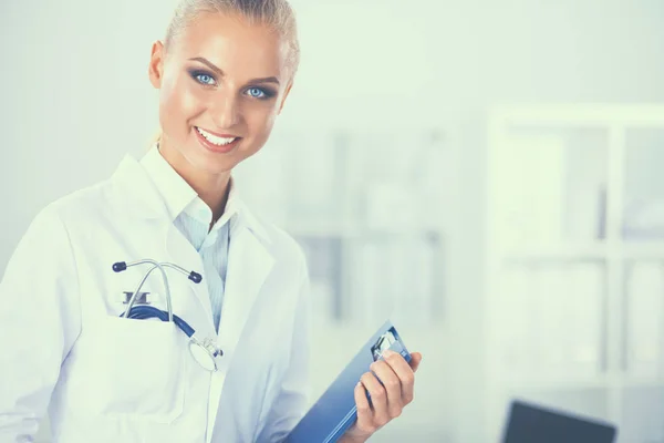 Woman doctor standing with folder at hospital