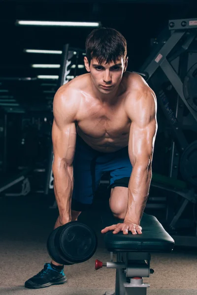 Sport, fitness, lifestyle and people concept -  flexing muscles with dumbbells in gym