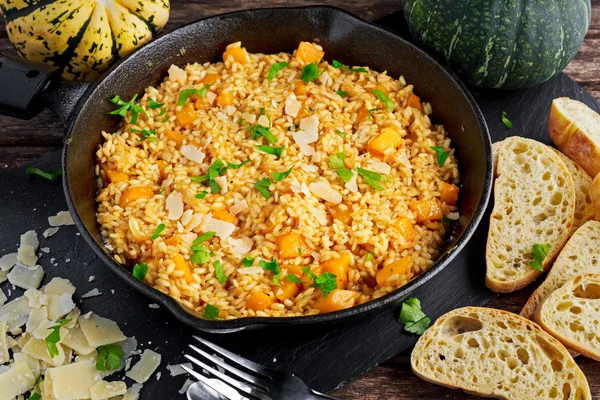 Pumpkin risotto in iron pan with Parmesan cheese, bread.