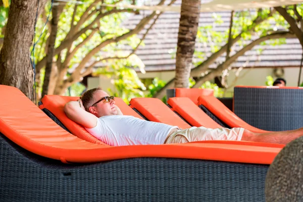 Man lying on a deck chair on a summer day