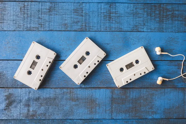 Top view of  Audio tape with earphones on blue wooden table background