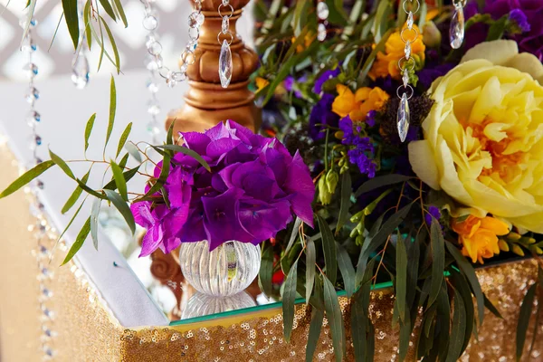 Floral arrangement to decorate wedding table in purple color. Th