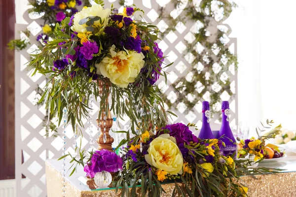 Floral arrangement to decorate wedding table in purple color. Th