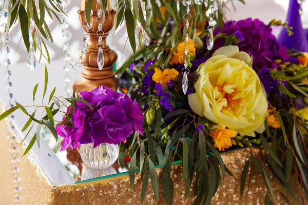 Floral arrangement to decorate wedding table in purple color. Th