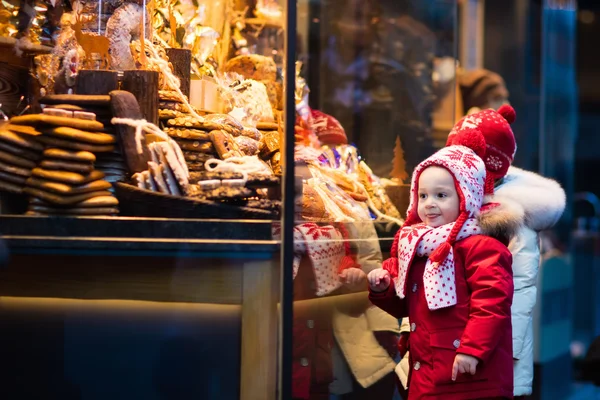 Kids looking at candy and pastry on Christmas market