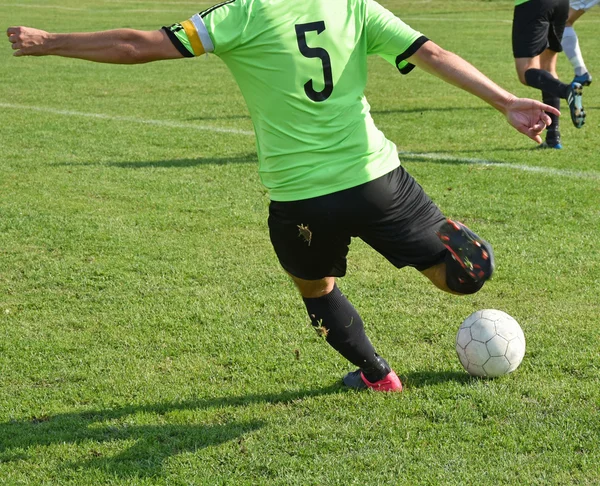 Soccer player kicks the ball