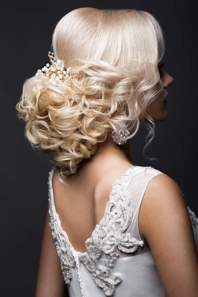 Beautiful blond girl in image of the bride with wedding accessories on her head. Beauty face. Hairstyle back view