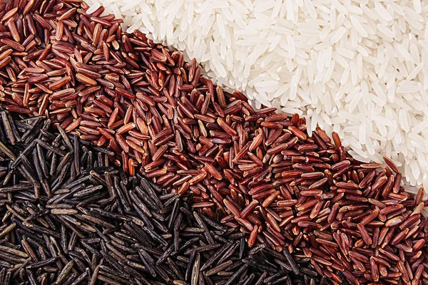 Strips of red, black and white rice close-up.