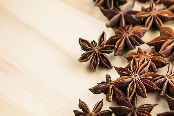 Anise star close up on wooden beige background.