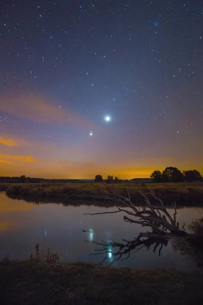 Stars Shining in sky at night over river